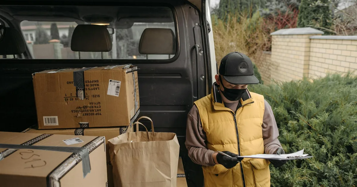 Courier measuring a parcel box dimensions for volumetric weight calculation at a Hyderabad doorstep pickup